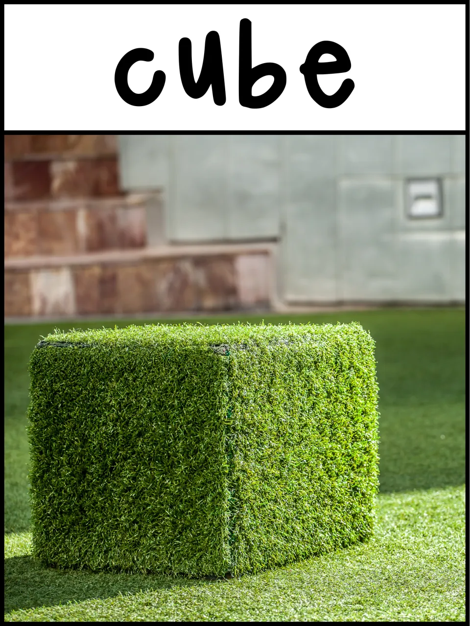 3D shape poster labeled 'cube' showing a large grass-covered cube outdoors as a real-life shape example