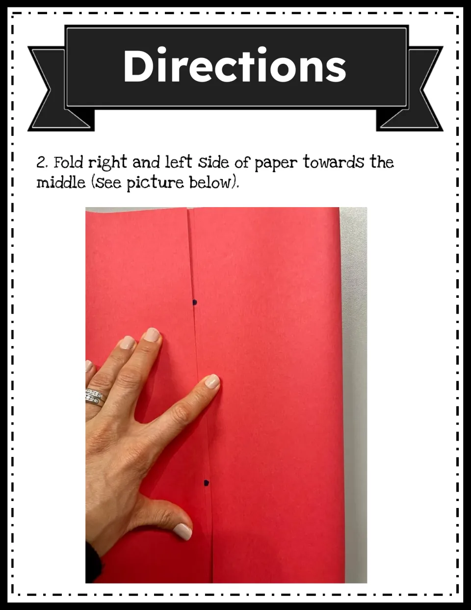 Directions step 2: photo of hands folding the left and right sides of the red paper in to meet at the marked middle