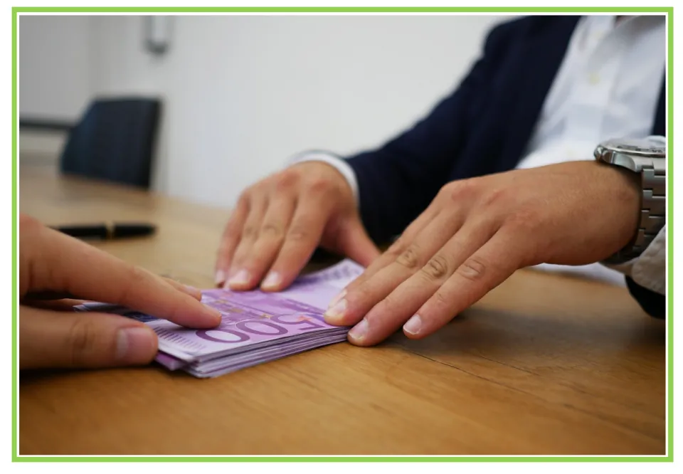 Deposit picture card: photo of hands passing a stack of 500 euro notes across a desk, unlabeled for sign recall