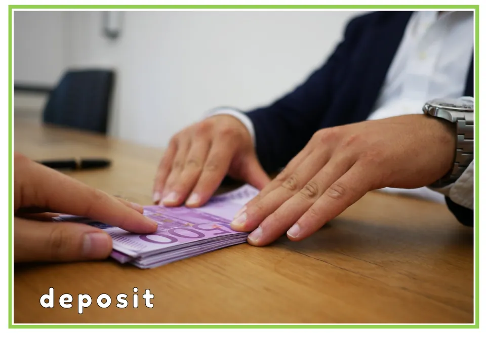 Deposit flashcard: hands handing over a stack of 500 euro banknotes on a desk, with the printed word deposit below