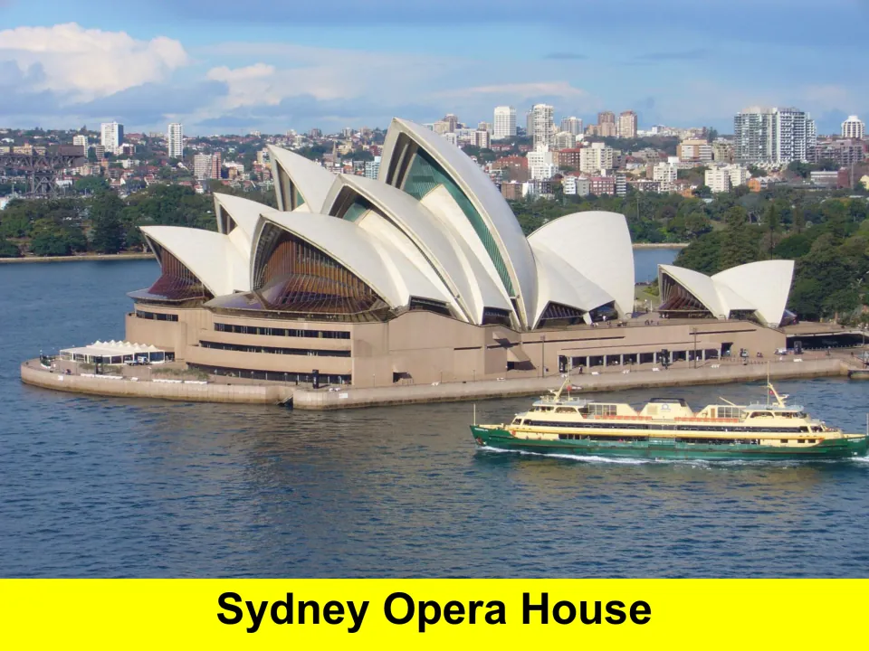 Sydney Opera House photo showing its white sail-shaped roofs on the harbour with a green and cream ferry passing by