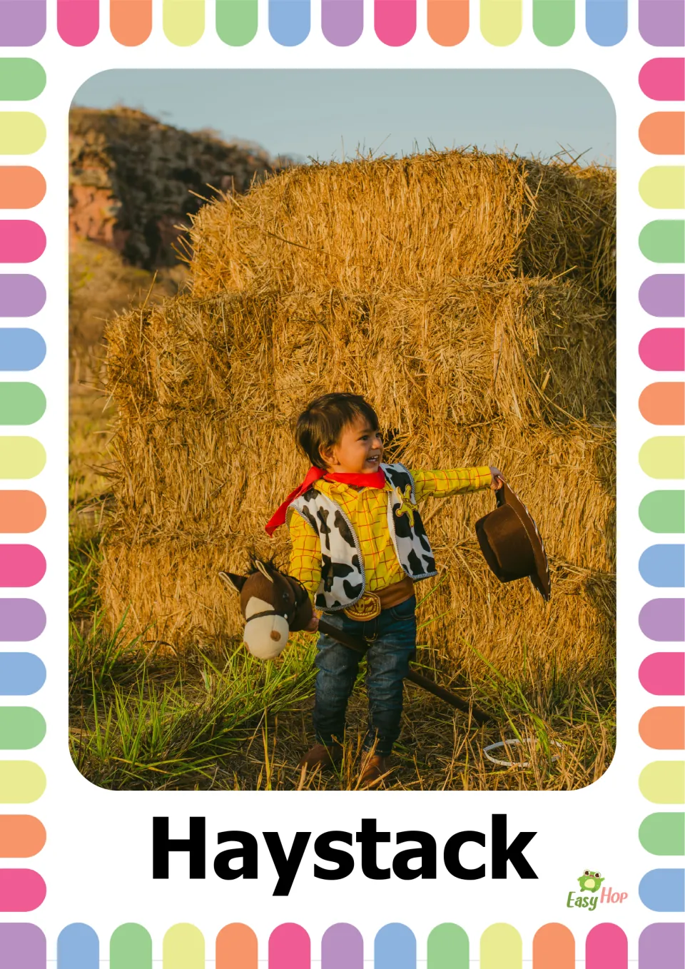 Autumn vocabulary flashcard 8: the word 'Haystack' beneath a photograph of stacked hay bales behind a child