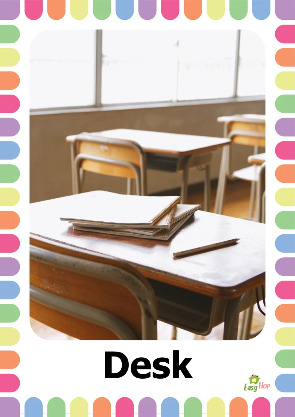 Vocabulary flashcard labeled 'Desk' showing a classroom desk with stacked spiral notebooks and a pencil