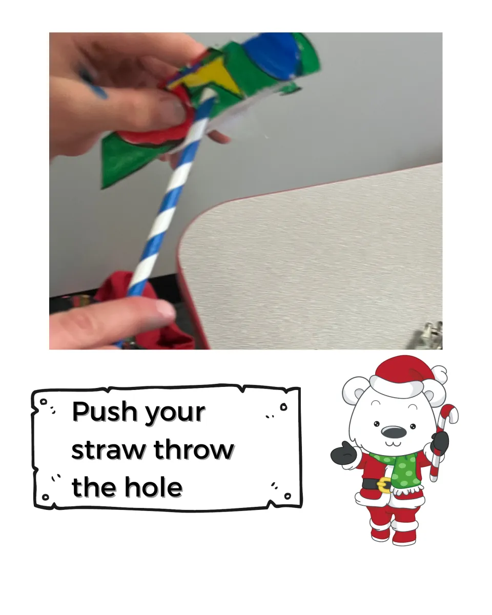 Push your straw through the hole: photo of a blue striped straw threaded through the folded paper tree