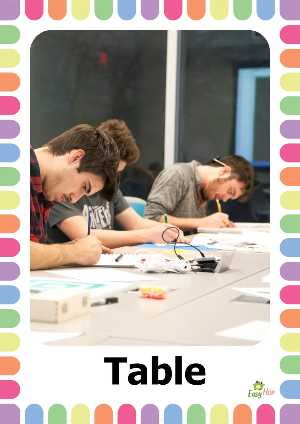 Table naming card: a photo of people writing with pencils at a long table covered in papers, labeled with the word Table