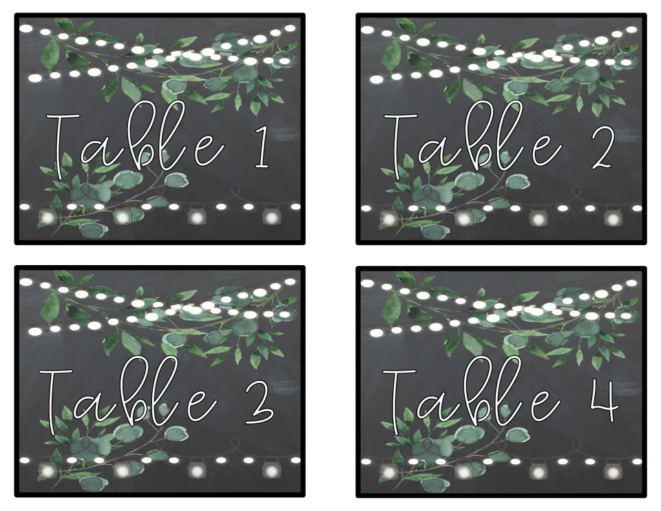 Chalkboard-style signs for Tables 1 to 4 with white script lettering, leafy greenery and strings of glowing lights