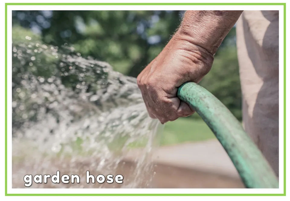 Labeled cleaning vocabulary flashcard showing a hand holding a spraying hose with the words 'garden hose'