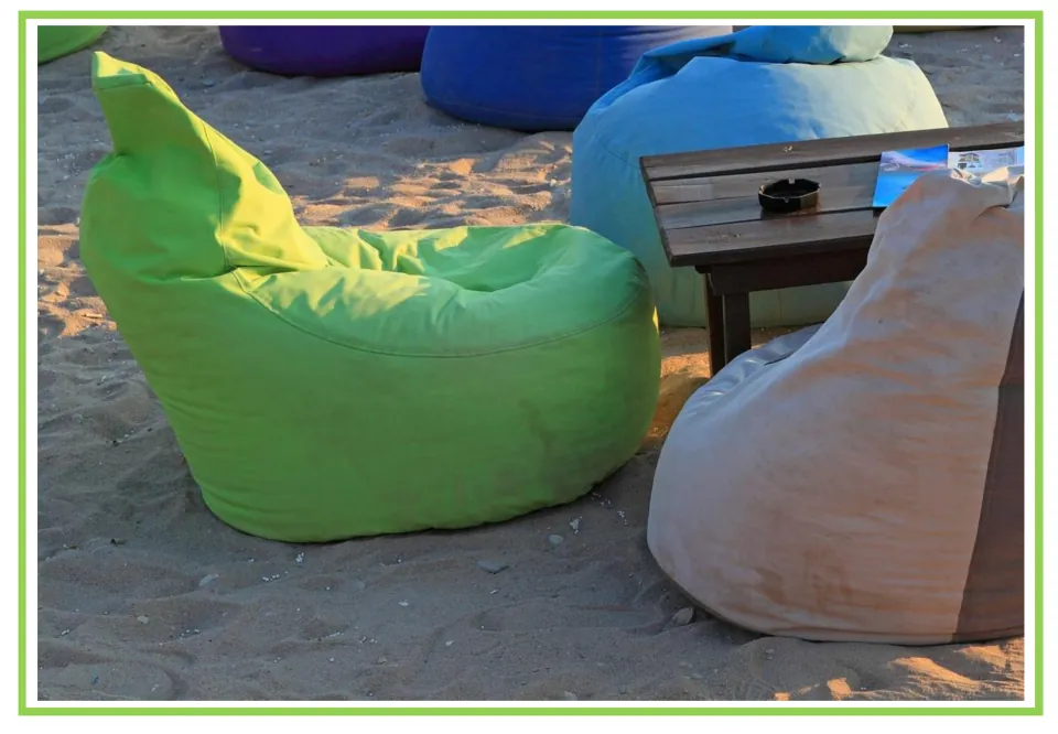 Picture-only garden vocabulary flashcard showing colorful beanbag chairs arranged around a table on sand