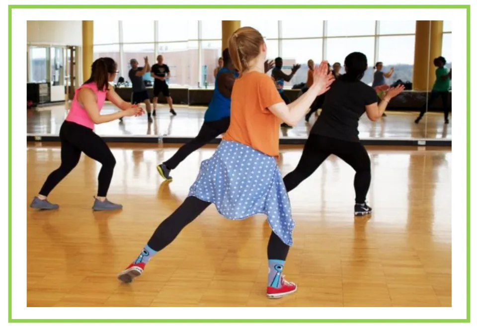 Picture-only gym vocabulary flashcard showing an aerobics class exercising together in a mirrored studio
