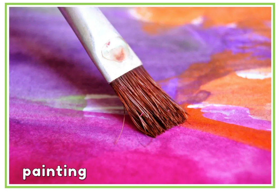 Labeled hobbies vocabulary flashcard showing a paintbrush on pink, purple and orange paint, labeled 'painting'