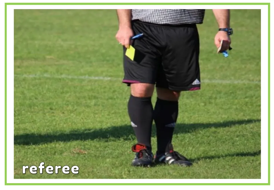 Labeled soccer vocabulary flashcard showing the word referee and an official holding a yellow card