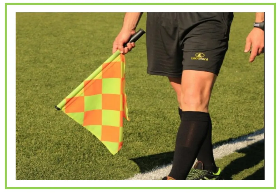 Picture-only soccer vocabulary flashcard for linesman, showing an official holding a checkered flag