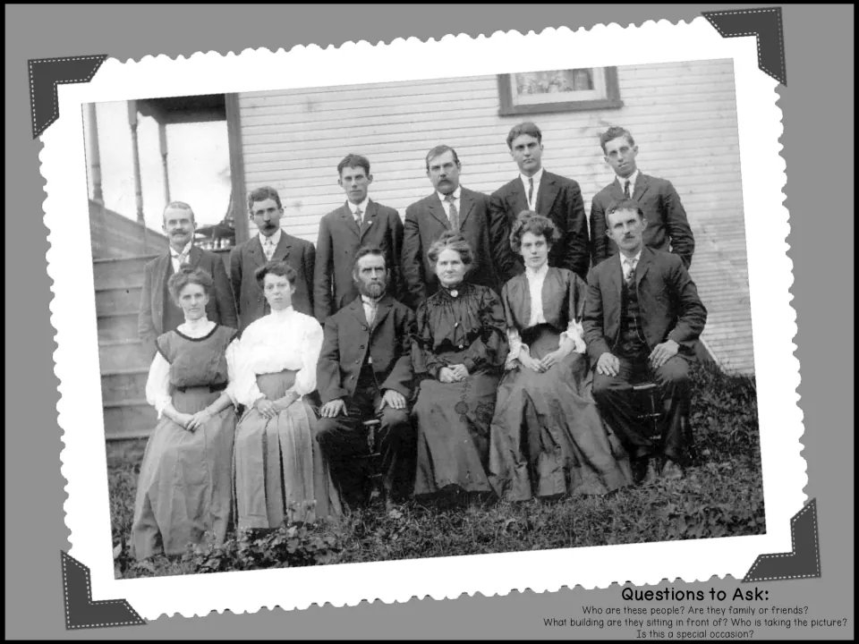 Old group photo of men and women posed before a house; students ask who they are, who took the picture and why
