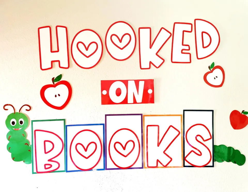 Valentine reading display photo: HOOKED ON BOOKS in red outline letters with heart O's, apples and a green caterpillar