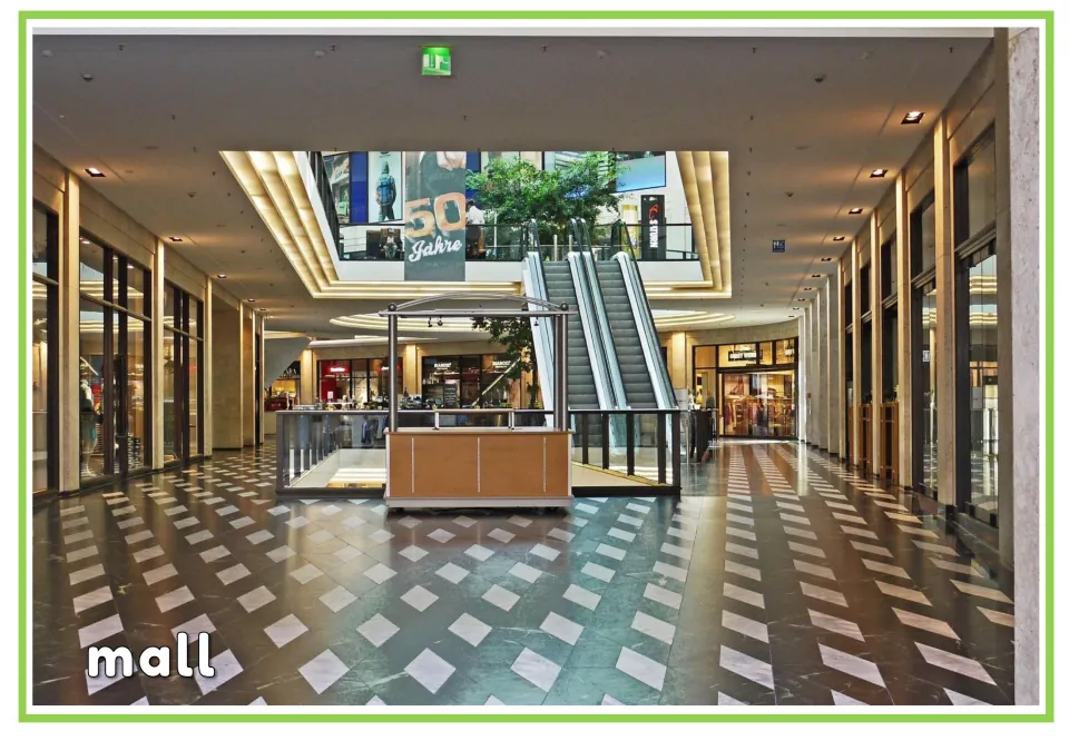 English vocabulary flashcard labeled "mall," showing an indoor shopping area with escalators and shops