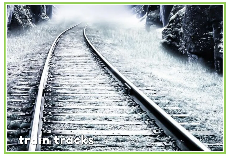 Labeled train tracks vocabulary flashcard showing curving railroad tracks with the words 'train tracks'