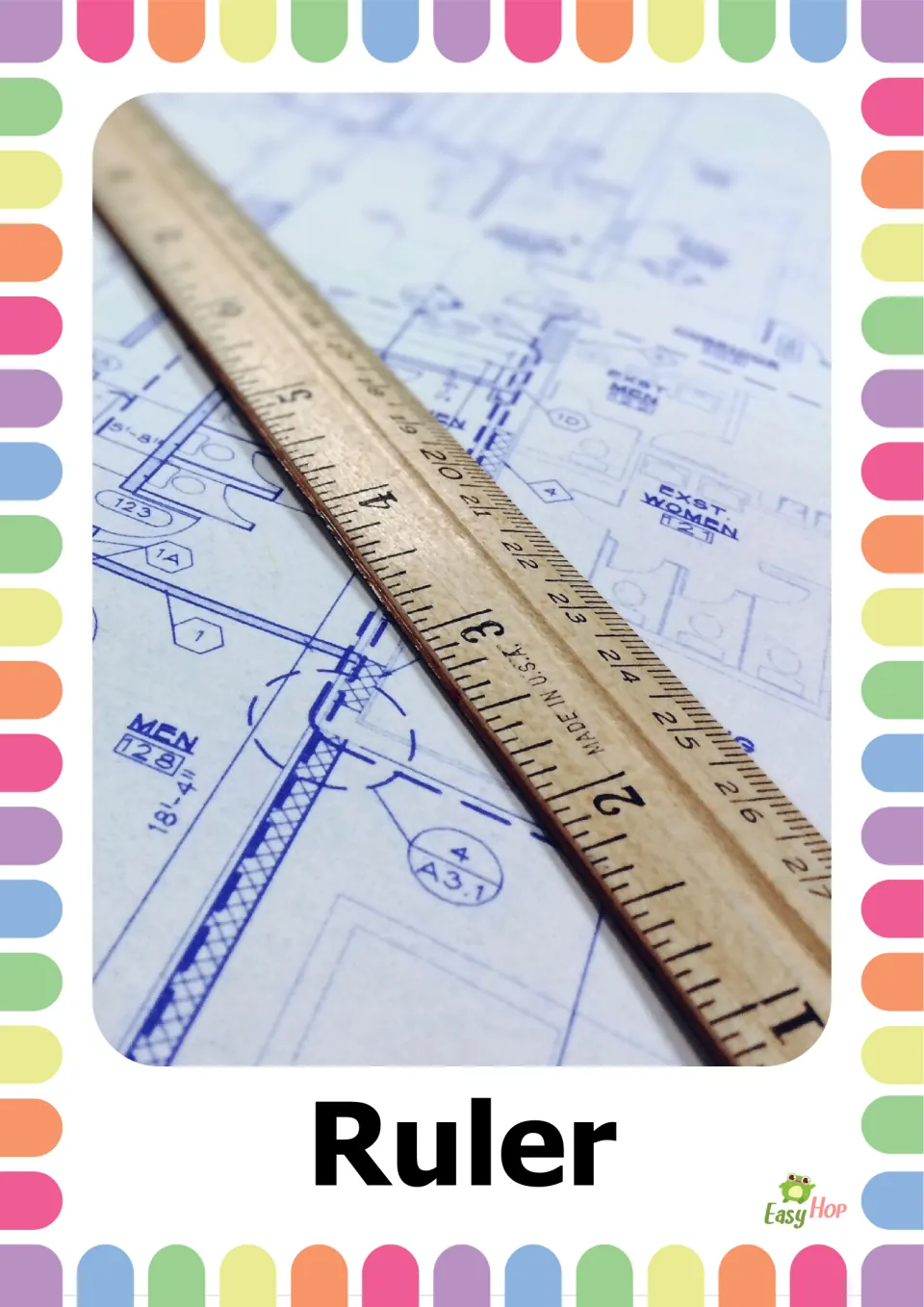 School supplies vocabulary flashcard labeled 'Ruler,' showing a wooden ruler resting on a technical drawing