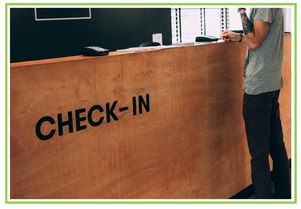 Picture-only Spanish hotel vocabulary flashcard for reception, showing a guest at a 'CHECK-IN' counter