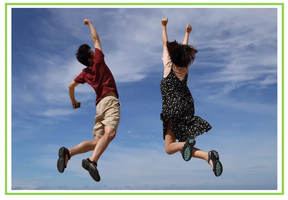 Spanish emotions flashcard without a label: two people jumping with raised arms to illustrate happiness