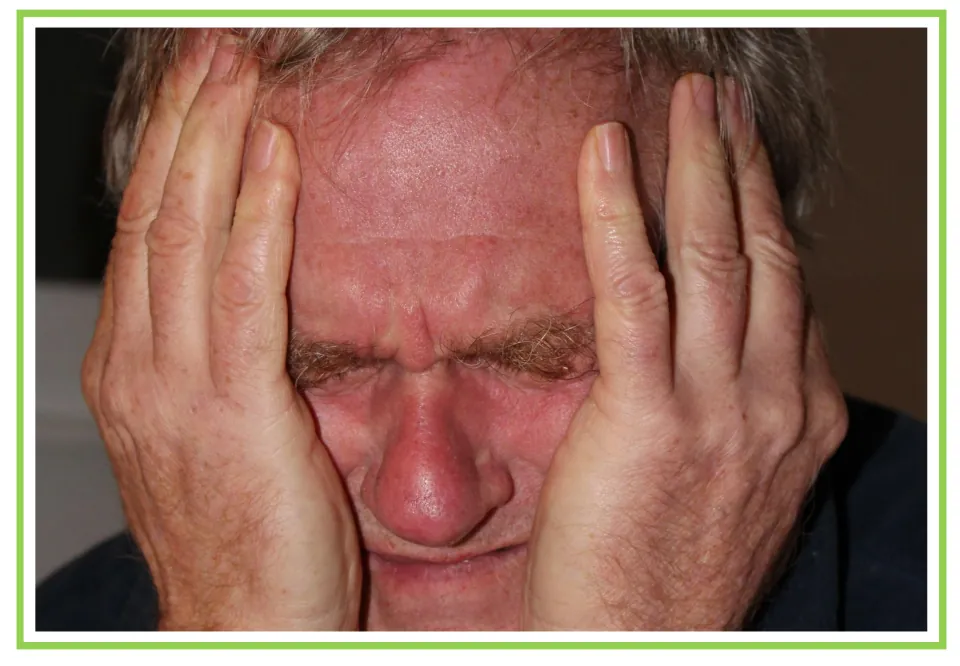 Spanish emotions flashcard without a label: a man holding his face in both hands to illustrate sorrow