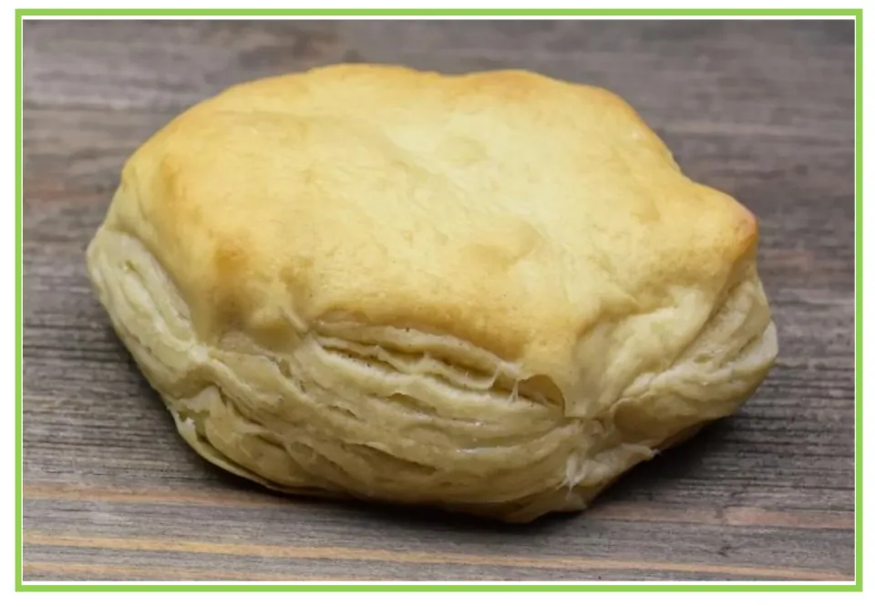 Picture-only Spanish bakery vocabulary flashcard showing a single golden pastry with visible flaky layers