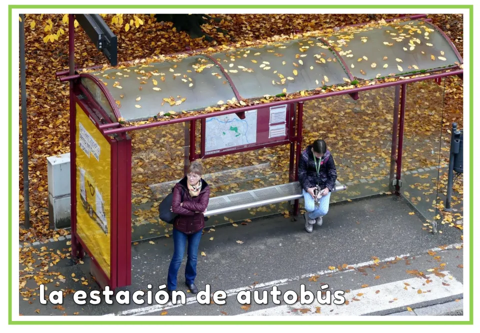 Spanish flashcard labeled 'la estación de autobús' (bus station), showing people at a bus stop shelter