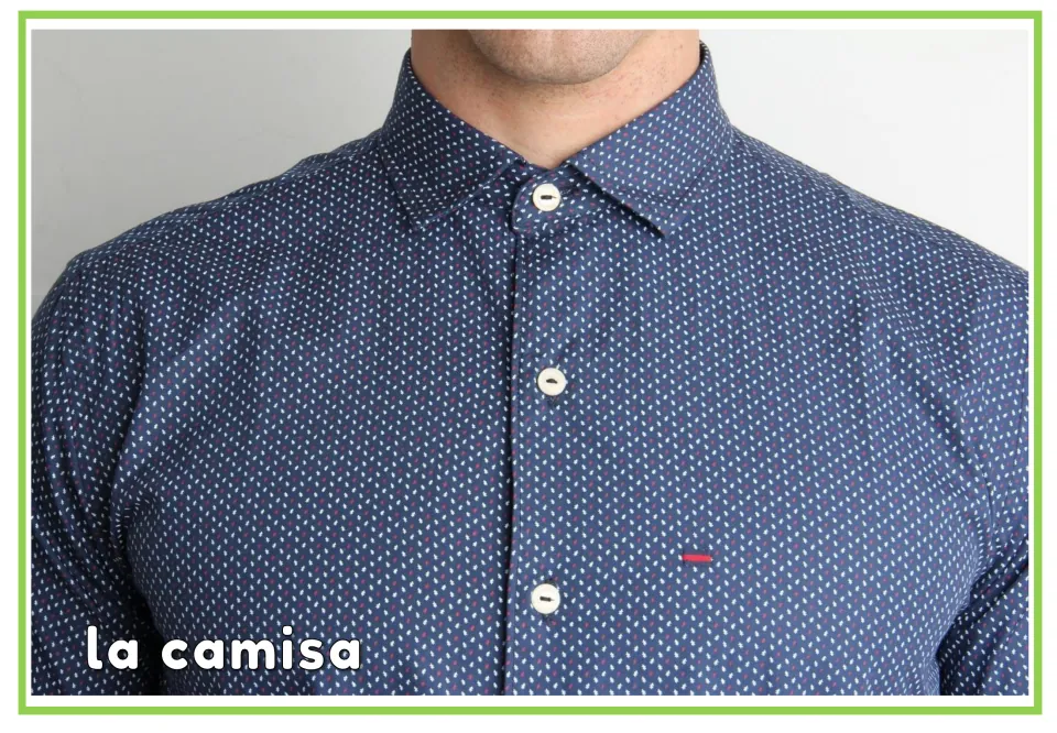 Spanish clothing flashcard labeled "la camisa" under a photo of a navy dotted button-up shirt, for learning the word shirt