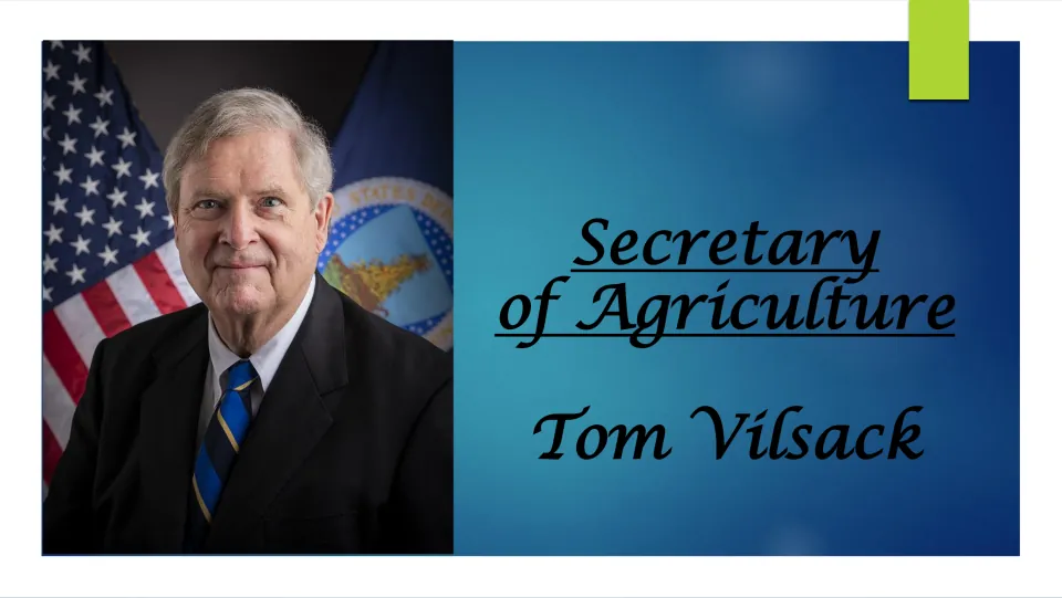 Biography slideshow title slide naming Tom Vilsack, Secretary of Agriculture, with his portrait in front of the U.S. flag