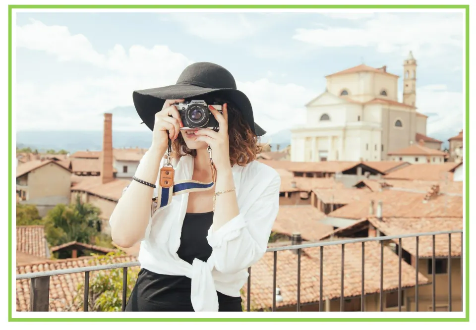 Hobbies writing and discussion prompt card showing a woman taking a photograph above a town's rooftops