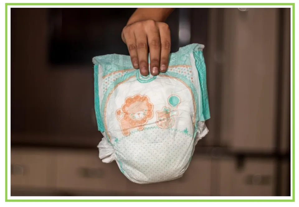 Hygiene discussion and writing prompt card 7 shows a hand holding a disposable diaper with animal designs.