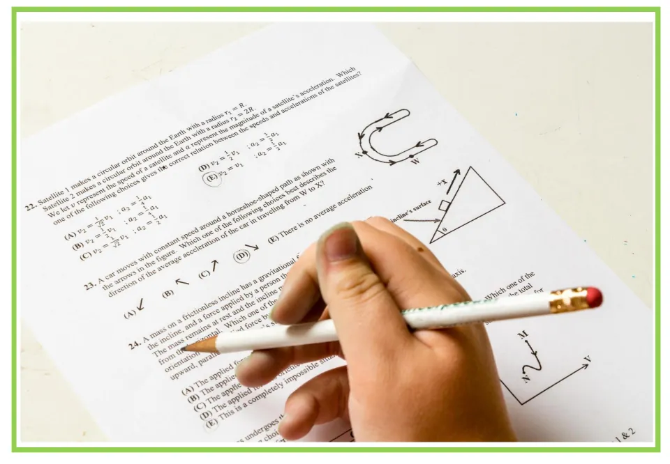 Exam flashcard: a hand holds a pencil over a physics test with multiple-choice questions 22 to 24, a moment to discuss