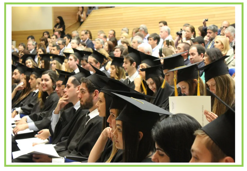 Graduation ceremony flashcard: graduates in black caps and gowns sit in rows with a crowd behind them, a scene to describe