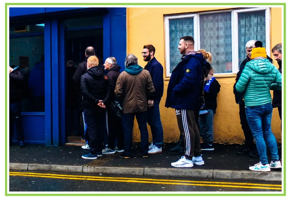 Bar and club discussion flashcard 1: people waiting in a line outside a building beside a blue entrance
