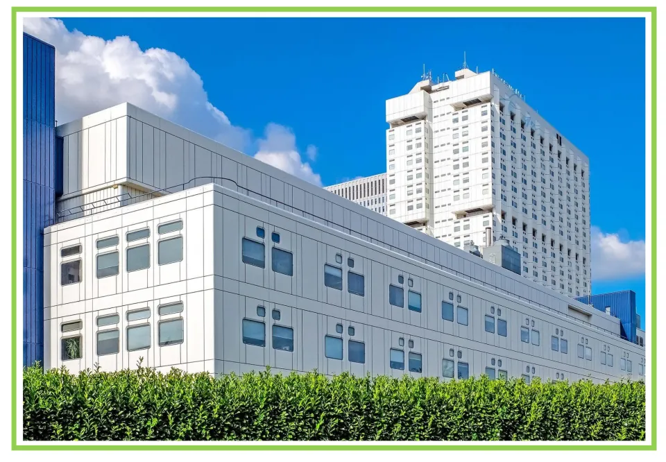 Building discussion and writing prompt card 6: a modern white building complex with a tall tower behind it