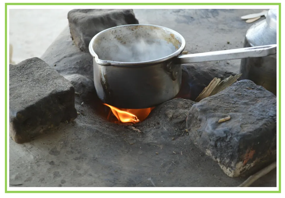 Camping writing and discussion prompt card 7: a steaming metal saucepan heating over a small wood fire