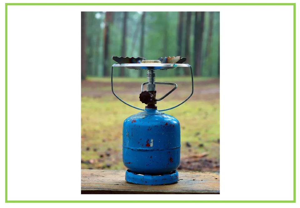 Camping writing and discussion prompt card 8: a portable gas stove mounted on a blue fuel cylinder outdoors