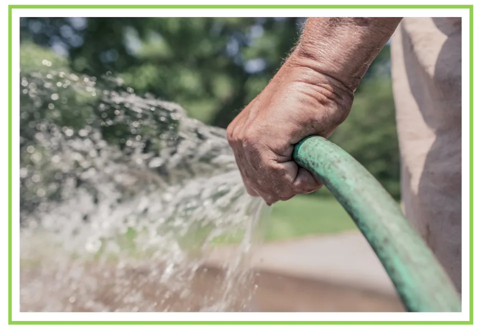Cleaning discussion flashcard showing a hand holding a green garden hose as water sprays from its end