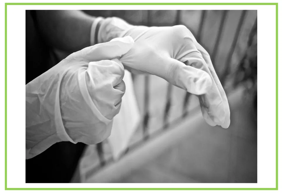 Cleaning discussion flashcard showing a person pulling on a disposable glove in a black-and-white photograph