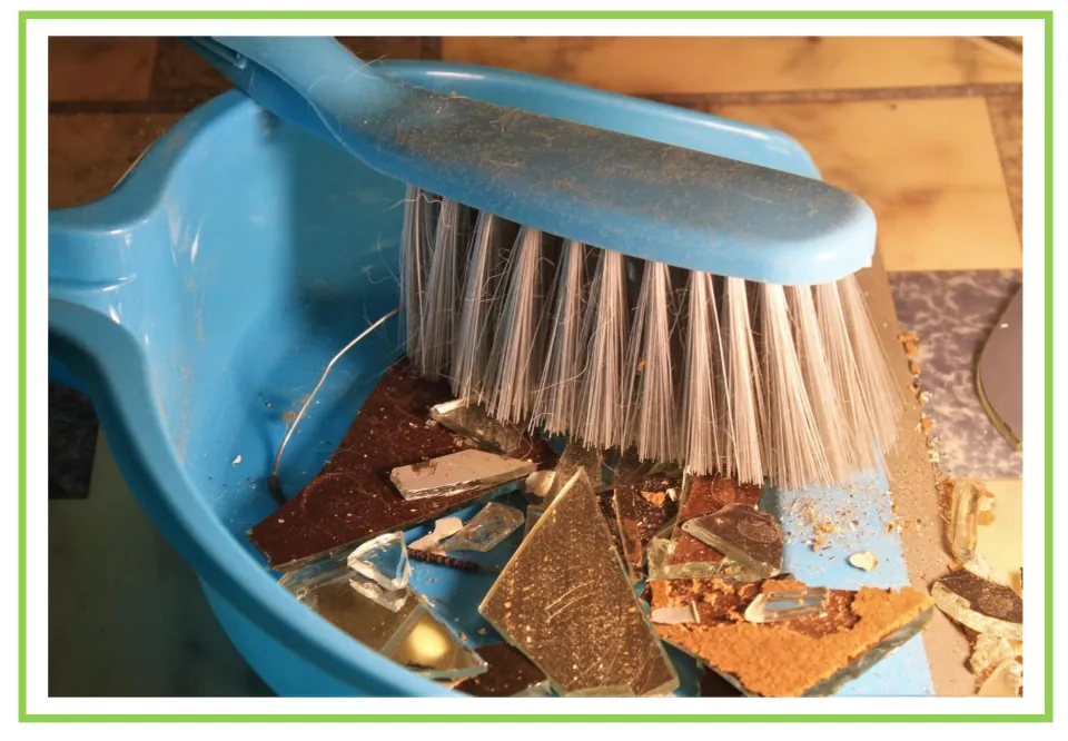 Cleaning discussion flashcard showing a blue hand brush resting across a dustpan filled with broken pieces