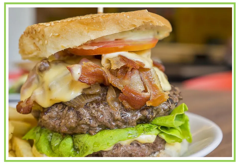 Coffee shop writing and discussion cue card 7: a burger stacked with bacon, cheese, lettuce, and tomato