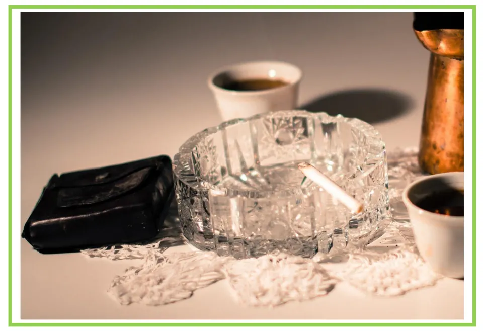 Coffee shop writing and discussion cue card 10: a cigarette resting in a glass ashtray beside coffee cups