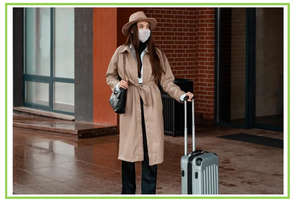 Hotel writing and discussion flashcard 9: a masked traveler stands outside an entrance with a suitcase