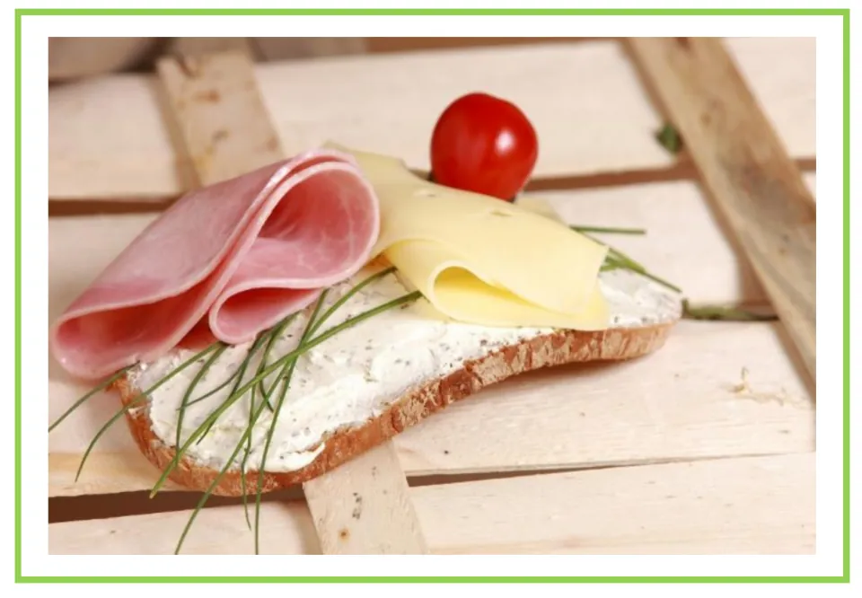 Meals and diet discussion flashcard 6: an open-faced sandwich topped with ham, cheese, spread, and chives