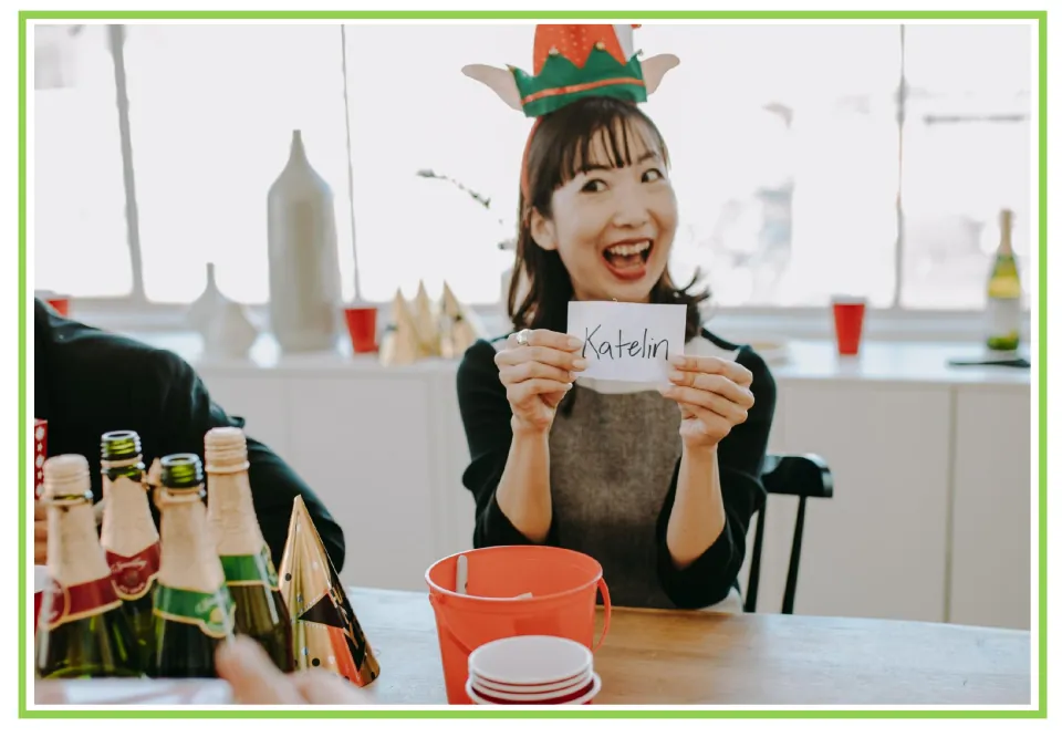 Party writing and discussion flashcard 2: a person wearing an elf hat holds a name card reading 'Katelin'