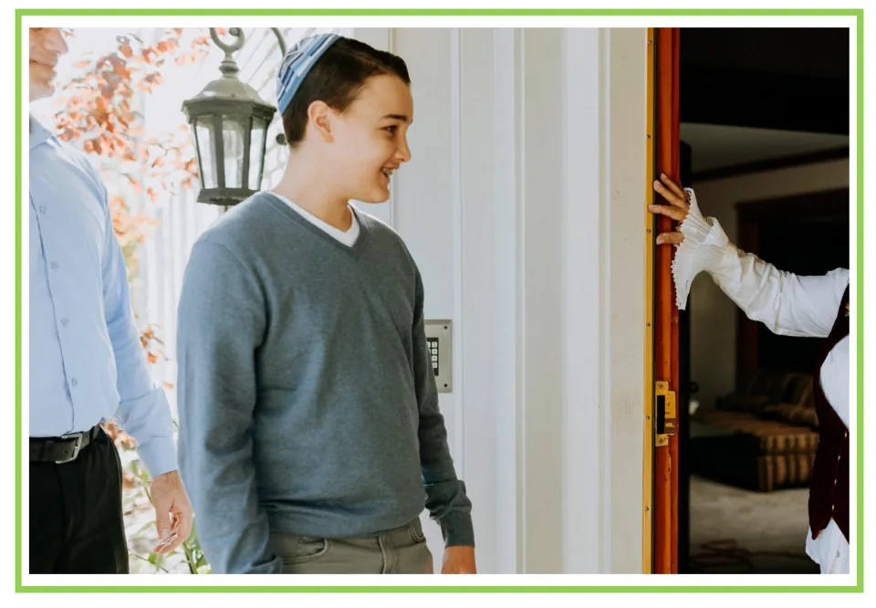 Party writing and discussion flashcard 4: a smiling visitor in a gray sweater stands outside an open door