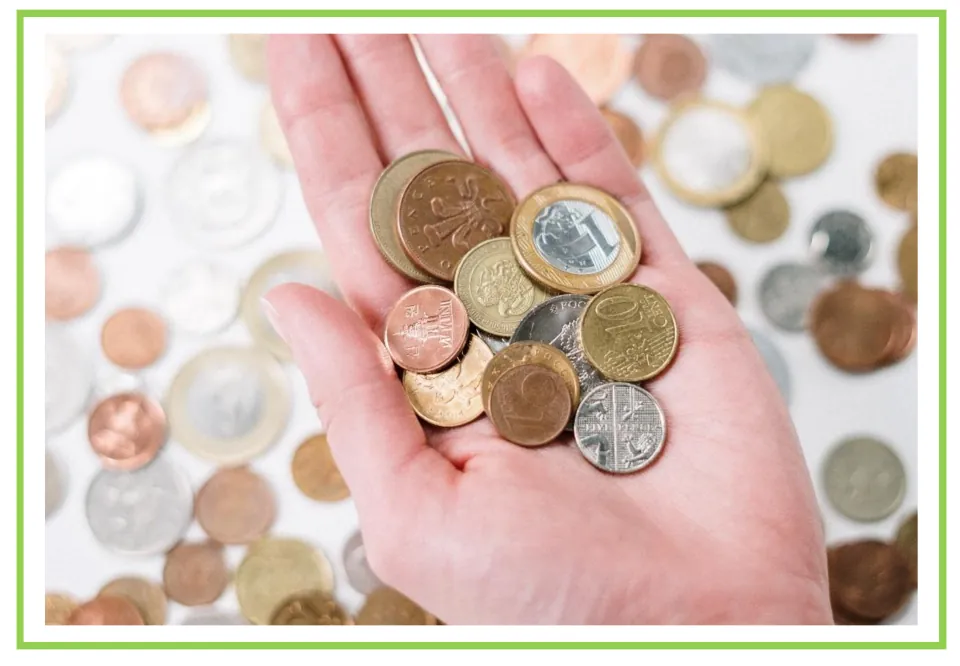 Shopping discussion and writing prompt card 9: an open hand holding assorted coins above scattered coins