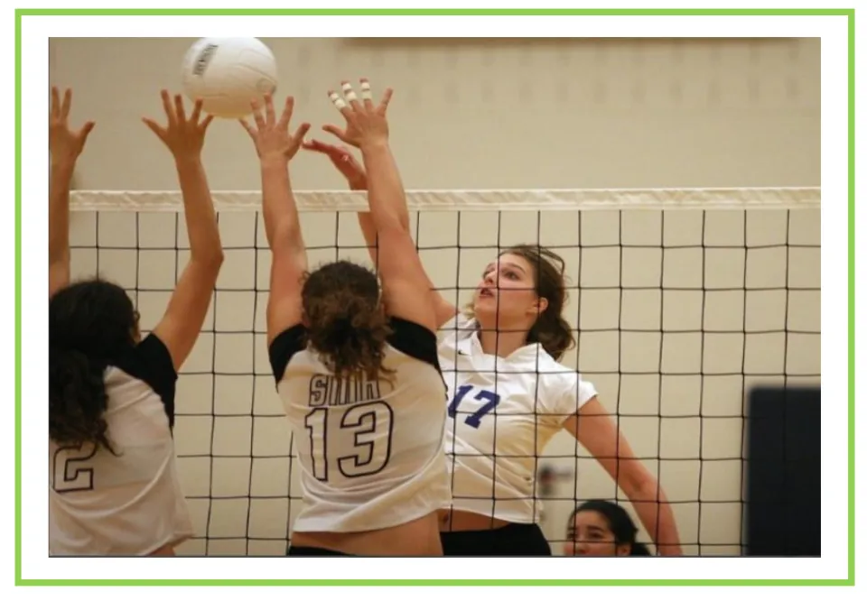 Volleyball writing and discussion flashcard showing players reaching above the net to block the ball