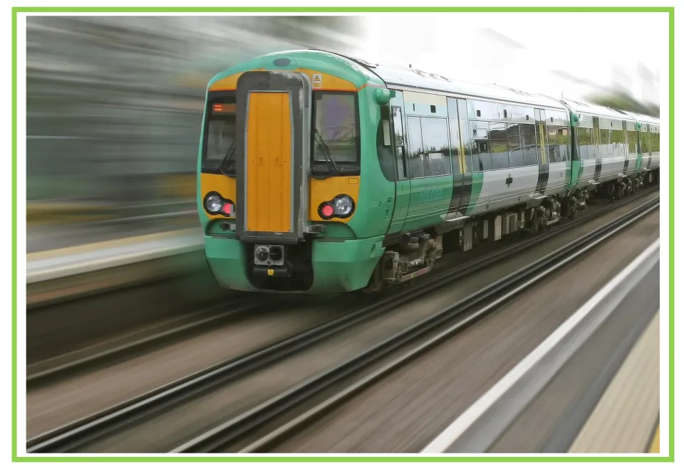 Train writing and discussion prompt card 1: a green and yellow passenger train traveling along tracks