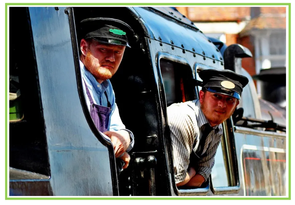 Train writing and discussion prompt card 10: two railway workers in caps leaning out of a locomotive cab